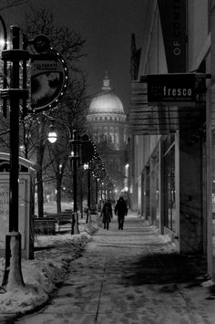 a person walking down a snowy street at night