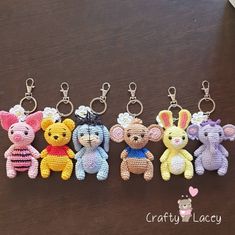 four crocheted keychains with small stuffed animals on them sitting on a table