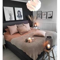 a bed with candles and pictures on the wall above it, in a bedroom setting