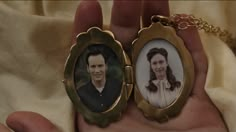 a person holding an old fashioned photo in their hand with a chain attached to it