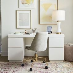 a desk with a chair, lamp and pictures on the wall