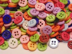 a pile of multicolored buttons sitting on top of a table