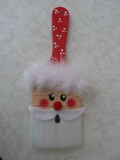 a santa clause toothbrush holder hanging on a wall with white and red fur around it