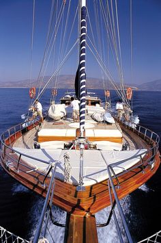 the front end of a sailboat sailing in the open water on a sunny day