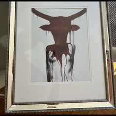 a framed photograph of a cow's head with blood dripping from it