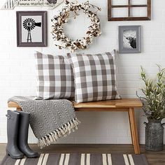 a bench with two pillows and some pictures on the wall