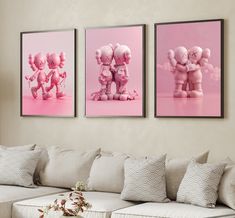 three pink elephants are hanging on the wall next to a white couch and coffee table