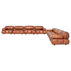 a brown leather couch and ottoman with wheels on each side, set against a white background