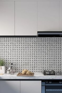 a kitchen with white cabinets and black counter tops is pictured in this image, there are two breads on the counter