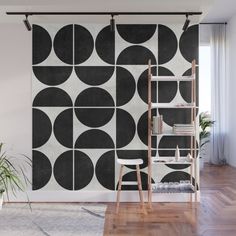 a black and white geometric wall mural in a living room with wooden floors, a ladder and potted plant