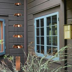 an outdoor lighting fixture hanging from the side of a house