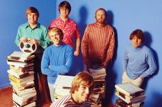 a group of men standing next to each other in front of stacks of books