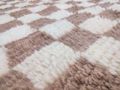 a brown and white checkered blanket on top of a bed