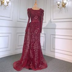 a dress on display in a room with white walls and chandelier behind it