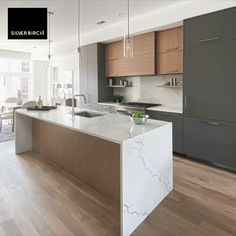 a kitchen with marble counter tops and wooden floors