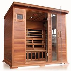 a wooden sauna with glass doors on the front and side sides, in an indoor setting