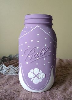 a purple mason jar sitting on top of a bed