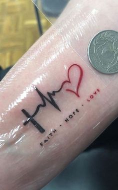 a person with a heart and heartbeat tattoo on their arm, next to a penny