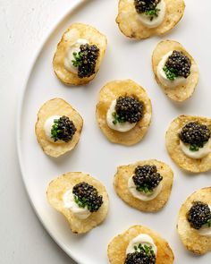 small appetizers with black cavia on them are arranged on a white plate