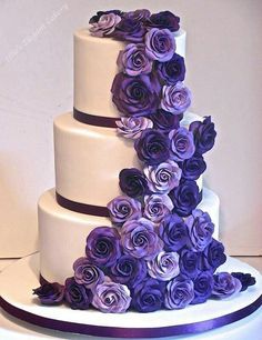 a three tiered cake with purple flowers on it