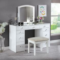 a white vanity with mirror, stool and flowers in vase on carpeted room floor