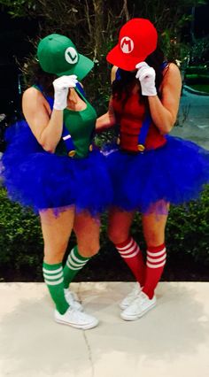 two women dressed up as super mario and luigi in tutu skirts with hats on