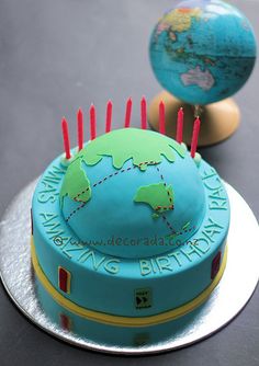 a birthday cake decorated with a globe and pins