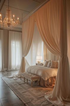 a large bed sitting under a chandelier in a bedroom