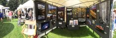 a group of people standing around a tent with pictures on it