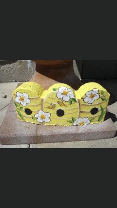 two yellow vases sitting on top of a stone slab next to a flower pot