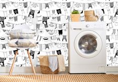 a washer sitting next to a dryer in front of a wall with clothes on it