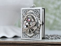 Vintage jeweled watch movement sets on custom silver plated over brass locket and it hangs on 18 inch surgical steel chain with lobster clasp. Measurement, Locket is about 1.4 inch (35mm) in length and 1.1 inch (27mm) in width on 18 inch chain. If you have a preferred length for the chain, please let me know in message to seller box and I will adjust it before shipping. Vintage Silver Stainless Steel Necklaces, Vintage Silver Stainless Steel Necklace, Collectible Antique Silver Stainless Steel Jewelry, Vintage Stainless Steel Pendant Jewelry, Steampunk Metal Jewelry Engraved, Steampunk Silver Engraved Jewelry, Steampunk Engraved Metal Jewelry, Steampunk Silver Necklace With Round Pendant, Spiritual Silver Locket Necklace