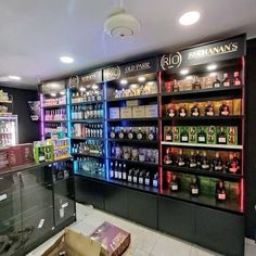 there are many shelves in the store with liquor bottles on them and one is empty