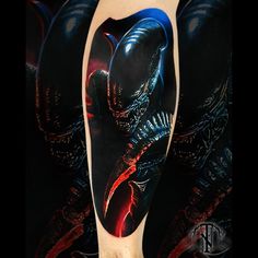 an arm with a tattoo on it that has a black alien and red light coming out of it