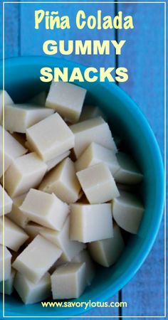 a blue bowl filled with cubed cheese on top of a wooden table