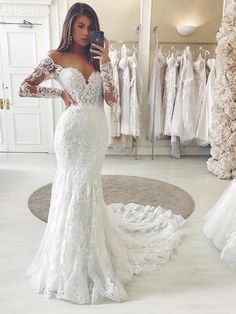 a woman is taking a selfie in her wedding dress while looking into the mirror