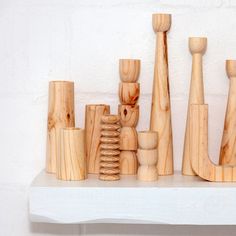 several wooden objects sitting on top of a white shelf