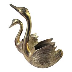 a brass swan figurine on a white background