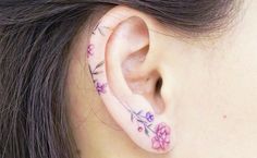 a close up of a person's ear with flowers on it