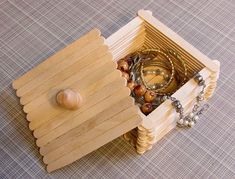 a wooden box with jewelry inside sitting on a table