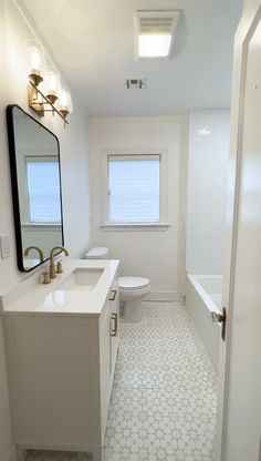 a bathroom with a sink, toilet and bathtub next to a window on the wall