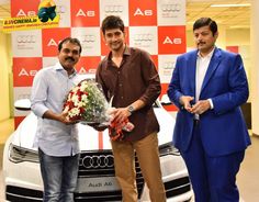 three men standing in front of a white car holding flowers and a bunch of roses