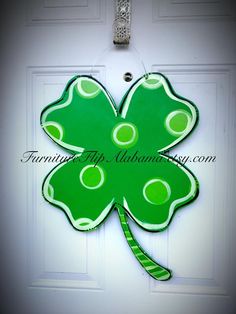 a green shamrock shaped door hanger on a white door