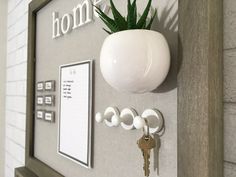 there is a plant on the wall with keys attached to it and a key holder