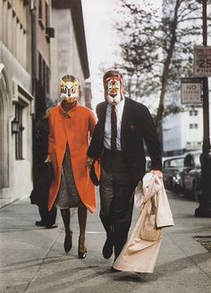 two people in masks walking down the street