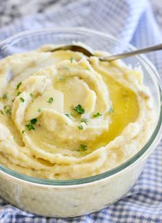 a bowl filled with mashed potatoes on top of a blue and white checkered cloth