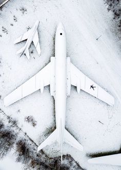 an airplane that is sitting on the ground in the middle of some snow covered ground