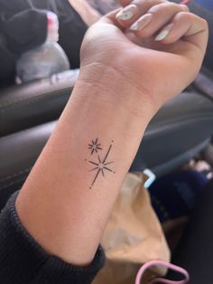 a woman's arm with a small star tattoo on it