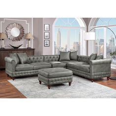 a living room with a large gray couch and footstool in front of a window