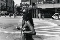 a woman with dreadlocks crossing the street